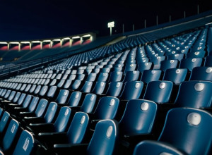 Scaune goale pe stadion la amurg, o eșarfă căzută, atmosferă solemnă, iluminare cinematografică, 8k, hiperrealist.